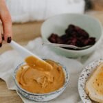 A cozy breakfast setup featuring creamy peanut butter, ready to spread on toast.